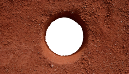 top view of a hole in red ground, exposed soil cavity, circular pit in textured dirt, excavation site, eroded terrain, isolated background
