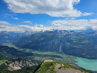 A stunning summer photo of Brienzer Rothorn, one of Switzerland’s most beautiful peaks, showcasing its majestic view over the surrounding Swiss Alps. The image captures the lush green landscapes and v