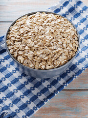 Oat Flakes in Gray Bowl on Blue-White Checkered Napkin, Copy Space