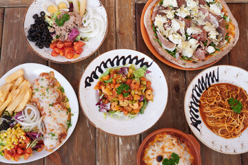 A table with a variety of food, including pizza, pasta, and salad