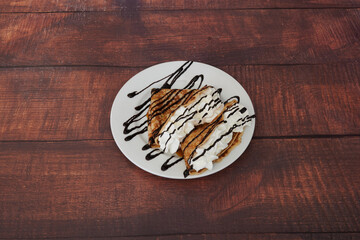 A plate of dessert with chocolate sauce and whipped cream on top