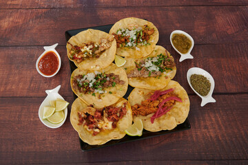A plate of Mexican food with a variety of tacos and a bowl of salsa