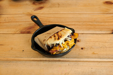A black pan with a sandwich in it