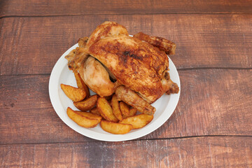 A plate of chicken and potatoes on a wooden table