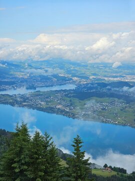 A stunning summer view from Mount Rigi, often referred to as the "Queen of the Mountains," offering panoramic vistas of the Swiss Alps and surrounding lakes. This image captures the lush green meadows