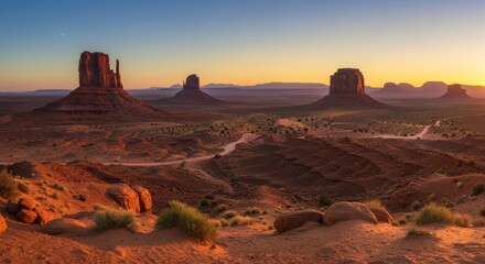 Naklejka premium Panoramic vista of monumental rock formations bathed in desert sunrise
