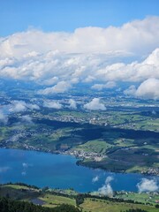A stunning summer view from Mount Rigi, often referred to as the "Queen of the Mountains," offering panoramic vistas of the Swiss Alps and surrounding lakes. This image captures the lush green meadows