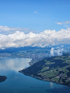 A stunning summer view from Mount Rigi, often referred to as the "Queen of the Mountains," offering panoramic vistas of the Swiss Alps and surrounding lakes. This image captures the lush green meadows