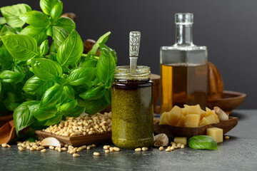 Pesto sauce and ingredients on a black stone table.