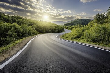 Winding asphalt road in the mountains, beautiful nature and forest landscape with sun rays shining through clouds on a summer day, winding mountain pass in the late afternoon