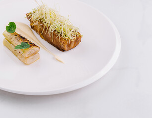 Gourmet leek and potato dish on white plate