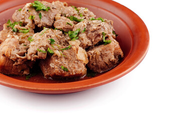 Stewed pork meat with herbs and spices on a plate