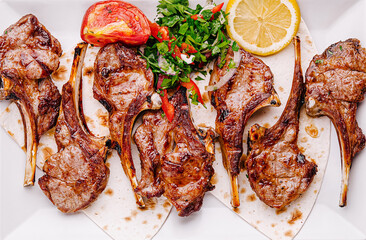 Delicious grilled lamb chops served with fresh garnish and lemon