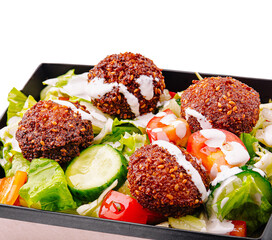 Fresh salad with crispy falafel balls and creamy dressing