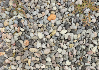 Texture of grey color of the crushed granite and limestone coarse gravel foreground closeup