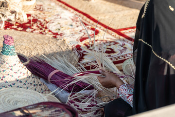 Close-up of hands weaving a basket from reeds, showcasing traditional craftsmanship and cultural heritage