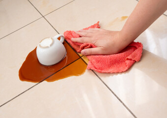 Spilled coffee, coffe puddle stain on tiled floor, messy leak with fallen cup, brown drink spillage