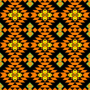 a geometric pattern with orange, yellow, and black tones. The symmetrical design consists of diamond and star-like shapes, evoking a tribal or ethnic textile style. Vector ethnic Navajo  American