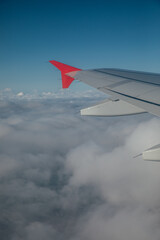 Fototapeta premium Airplane wings against blue sky background with clouds in flight