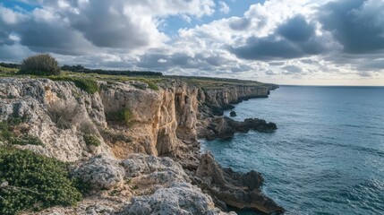 Coastal cliffs meet the ocean under dramatic sky. Possible use Stock photo for nature or travel publications