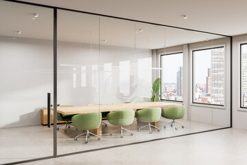 Modern office interior with glass-walled conference room, wooden table, and green chairs. Bright...