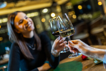Young couple who is in love toasting with wine at romantic dinner date.