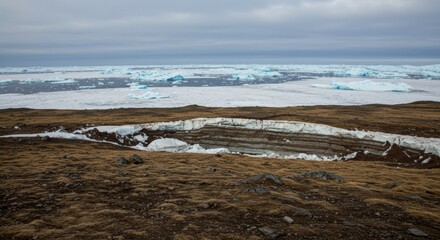 Arctic landscape with permafrost thaw and melting icebergs beyond the coast