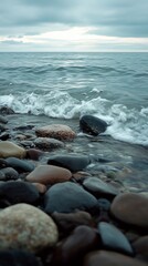 Fototapeta premium Serene rocky shoreline with gentle waves under overcast sky