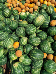 lots of ripe watermelons and yellow melons for food as background
