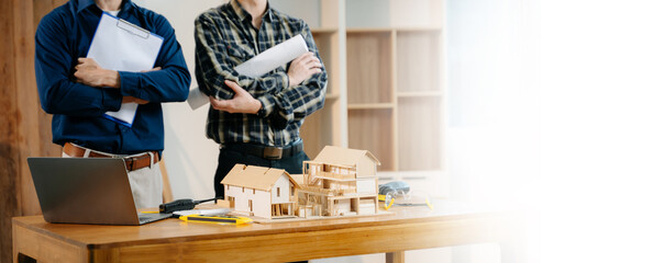 Colleagues discussing data working and tablet, laptop with architectural project at construction...
