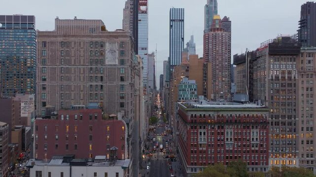 Glowing Manhattan cityscape in Flatiron District capturing Fifth Avenue dynamism, architectural silhouettes, bustling traffic streams