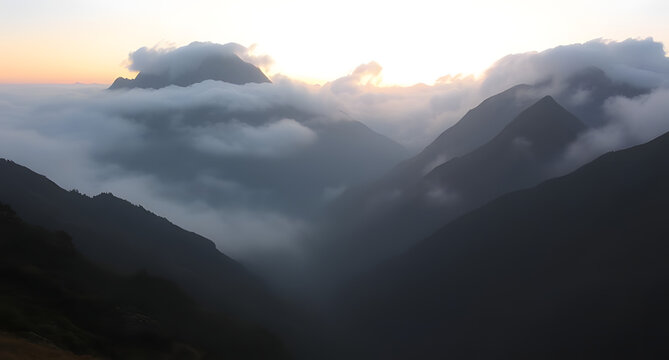 Misty mountain valley at sunrise background. Low clouds rolling between jagged peaks