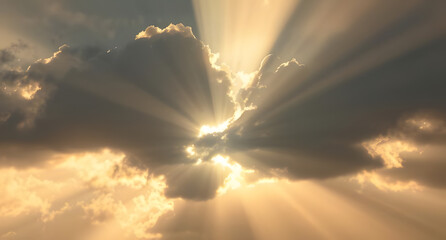 Sun rays piercing through dark clouds background. Dramatic beams of golden light breaking through