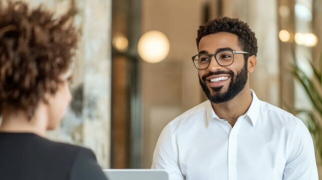 Professional hotel supervisor coaching a team member in a welcoming lobby environment, promoting effective communication and leadership strategies.