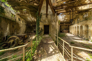 Railings in an old abandoned power station divide the room into several parts in a ypsilon-shaped...