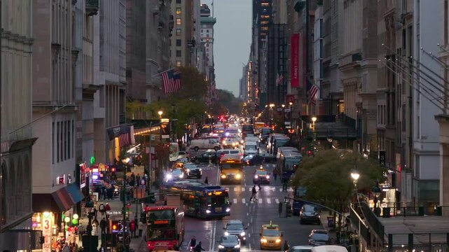Warm golden sunlight bathing Fifth Avenue in Manhattan, traffic streaming through New York City's iconic urban landscape with vehicles navigating metropolitan scene
