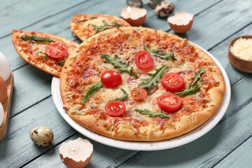 Easter pizza with bunny ears, eggs and cheese on grey wooden background