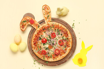 Easter pizza with ears, eggs and paper bunnies on yellow background
