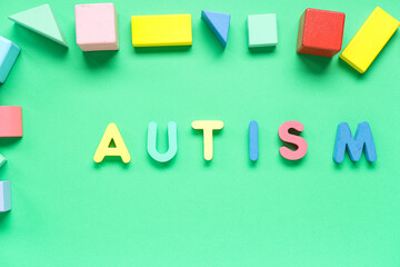 Word AUTISM with colorful blocks on green background