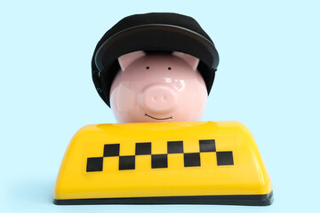 Piggy bank in driver's hat with taxi roof sign on blue background