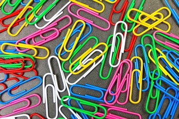 Multicolored paper clips on a gray background