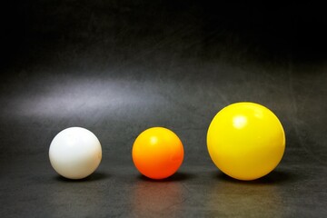 Three different balls on a gray background