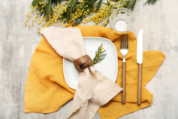 Beautiful table setting with mimosa flowers on grey background