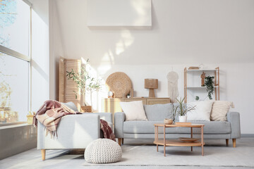 Interior of stylish living room with grey sofas, coffee table and big window