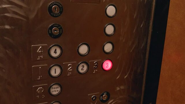 Man Pushing a Elevator Button for the third floor