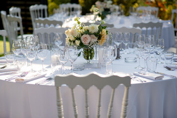 Elegant floral centerpiece adorning a beautifully arranged wedding reception table under soft evening light