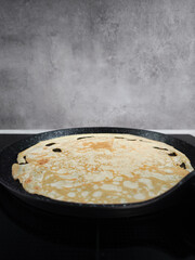 Cooking crepe on frying pan for shrove tuesday, maslenitsa or breakfast celebration copy space