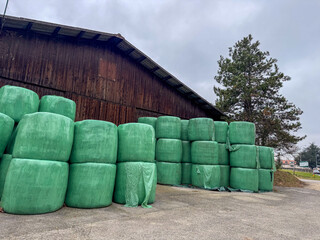 Stacked Green Hay Bales by Barn