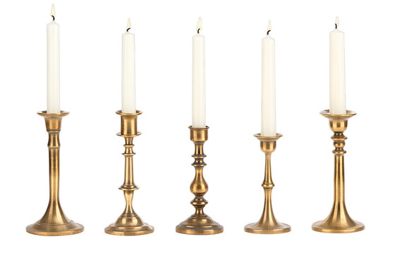 Five ornate brass candle holders with lit taper candles on transparent background