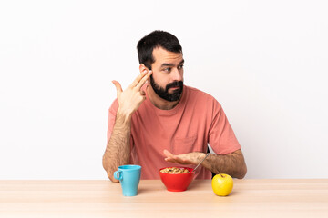 Caucasian man having breakfast in a table with problems making suicide gesture.